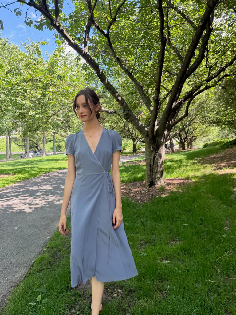 Front walking view of lavender blue silk wrap midi dress.